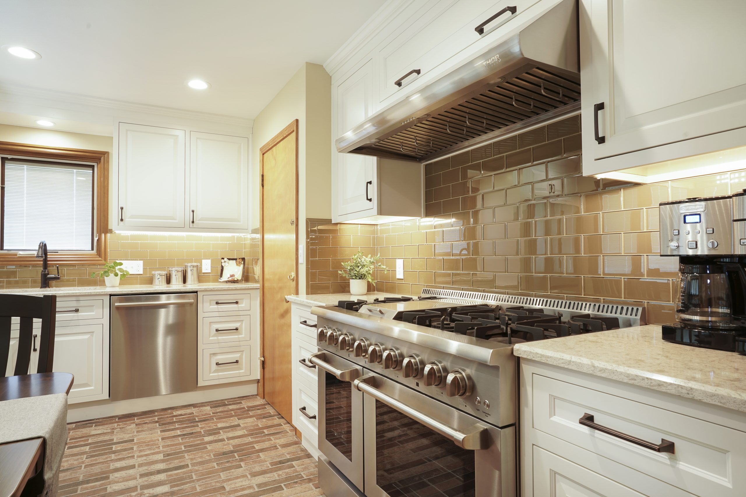 Updated kitchen with stainless steel appliances and white countertops and cabinets.