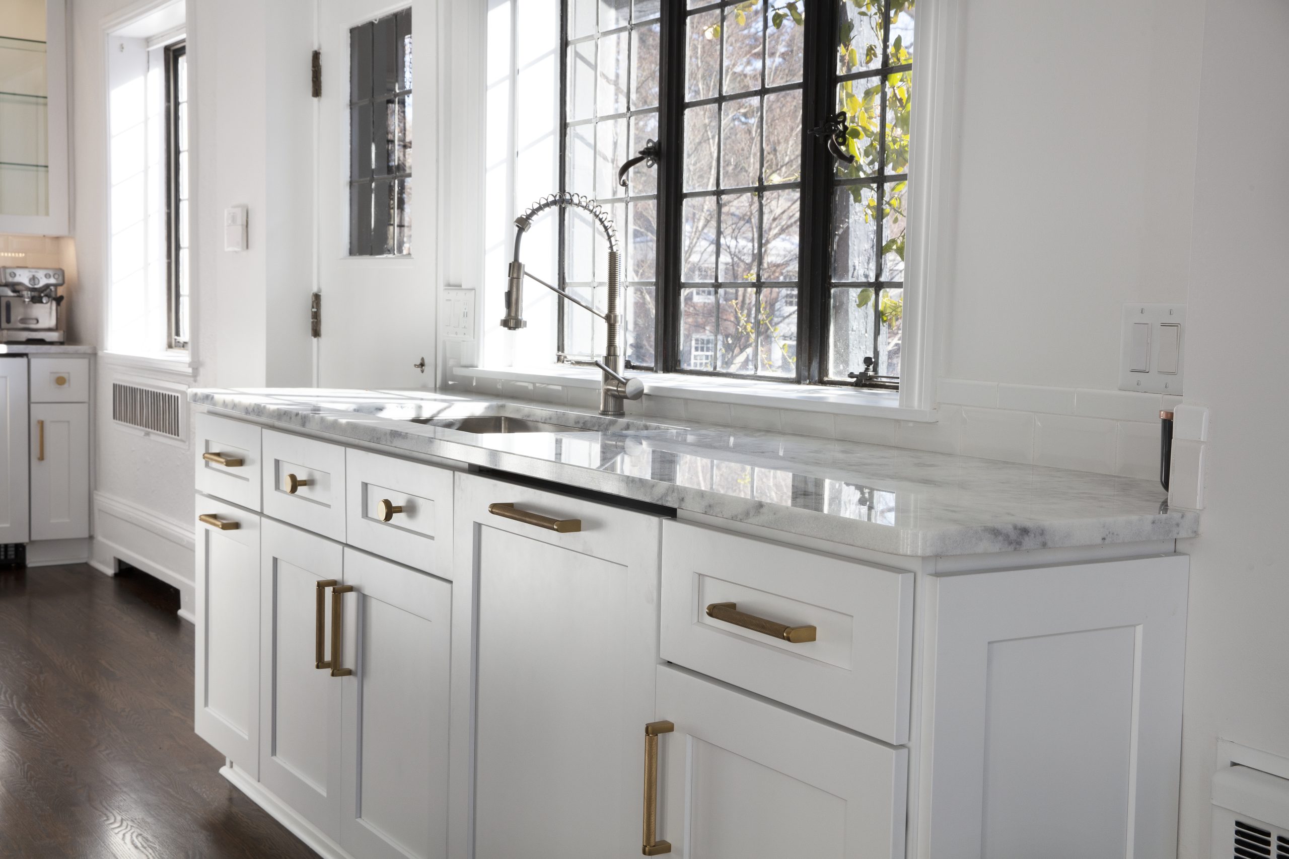 Remodeled kitchen with white cabinetry and stone countertops.